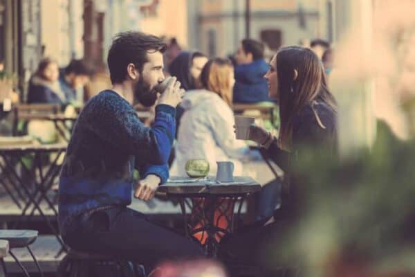 A man and woman sitting in a cafe talking